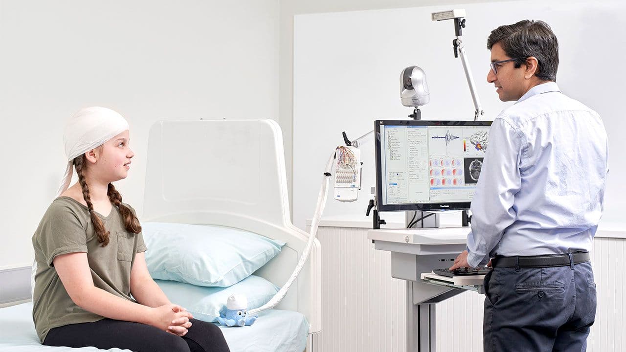 Doctor talks to a young patient wearing sensor equipment