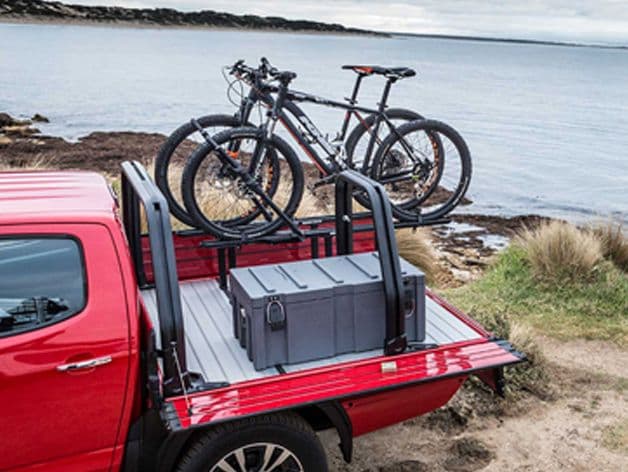 Actual truck bed with bikes and storage box inside, side and back flap lowered