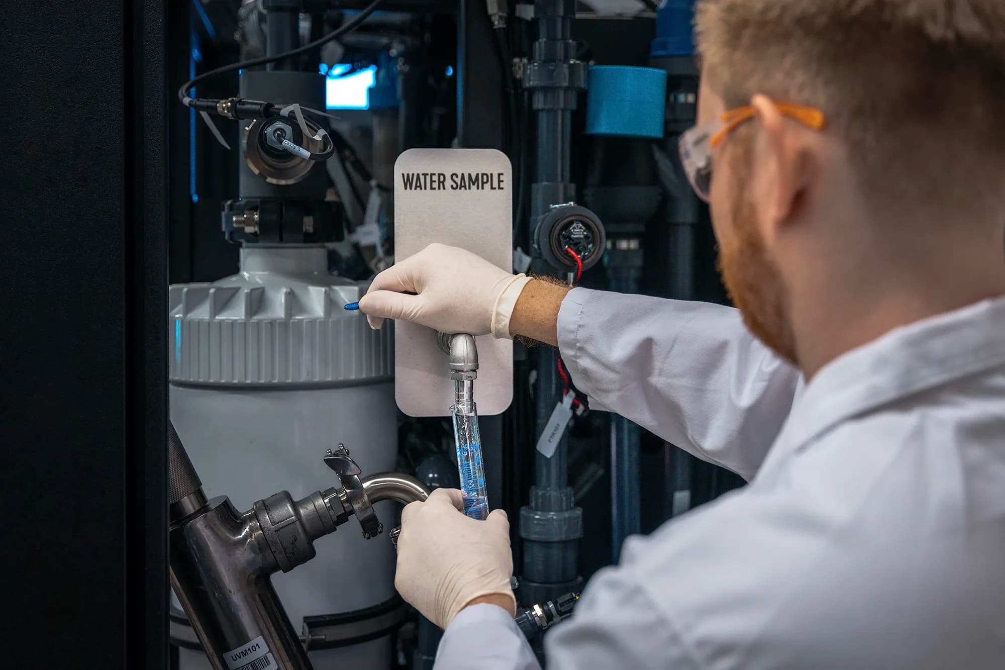Technician takes a water sample from the dedicated outlet