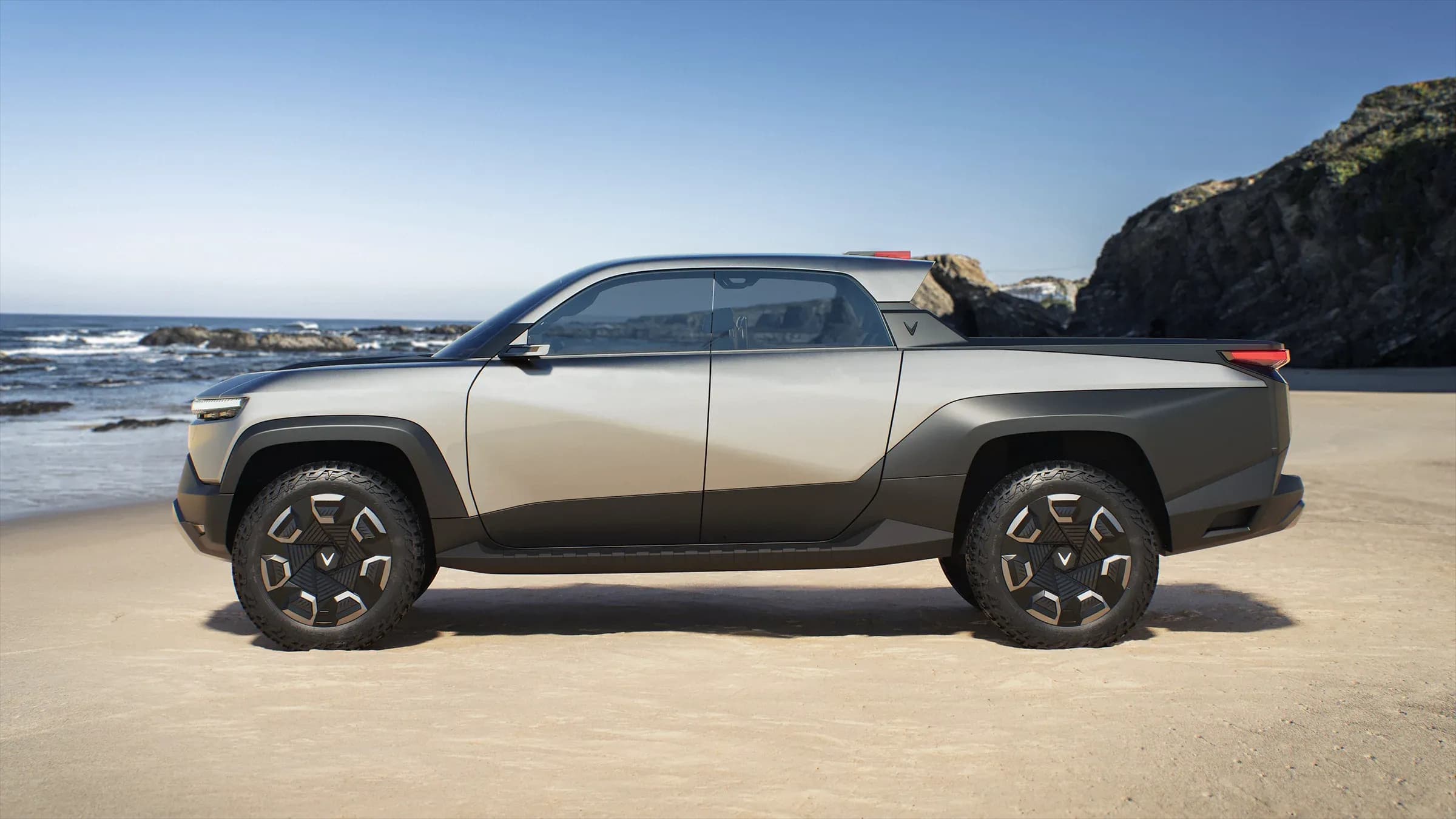 Vinfast promotional photo at a beach, with the doors closed, showing the designed bodylines of the vehicle