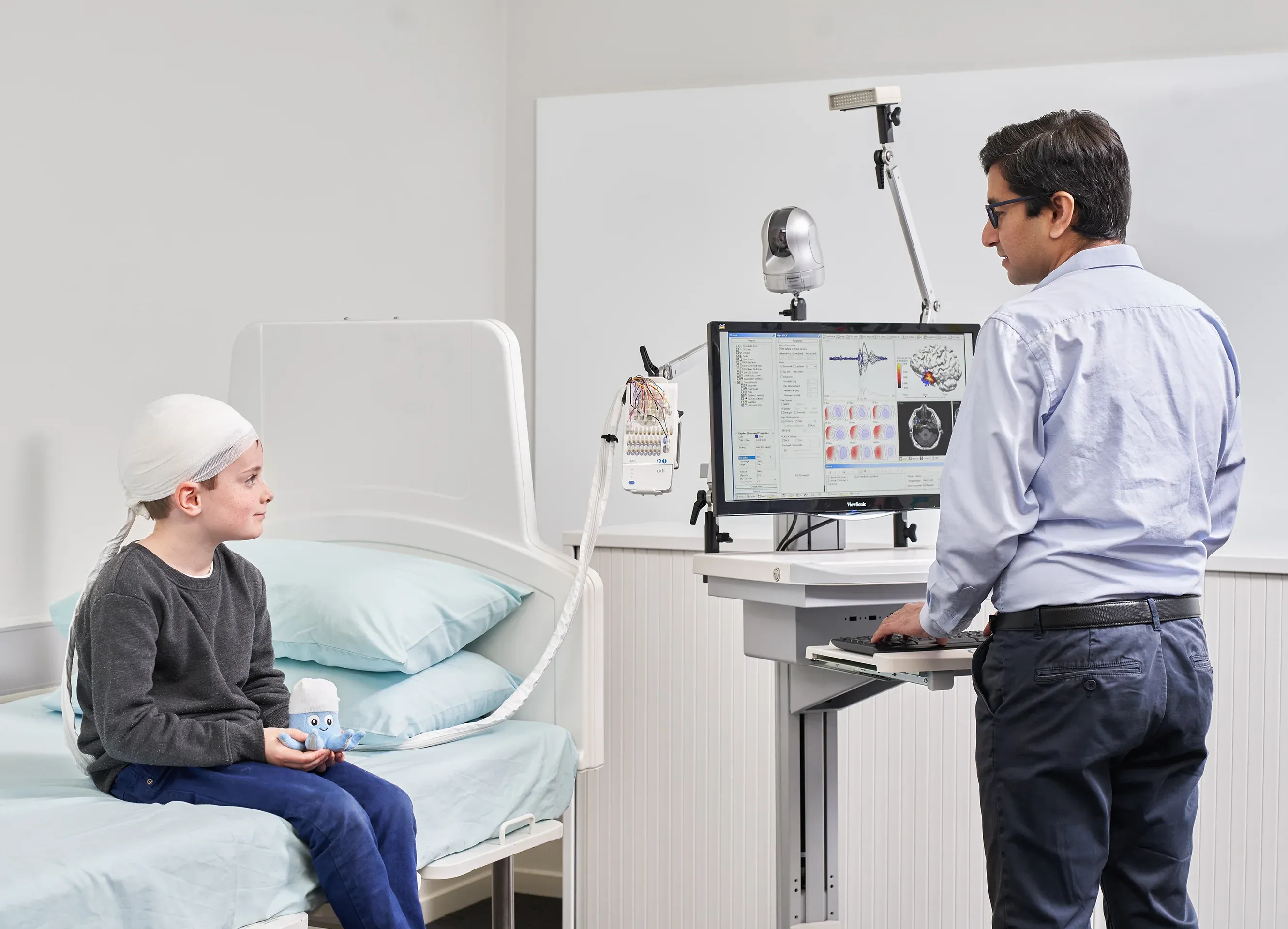 Youth on a bed with the unit, talking to a surgeon
