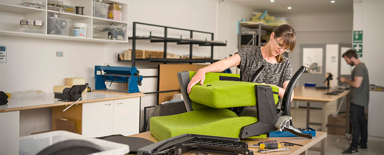 designer in workshop with theatre seat prototype