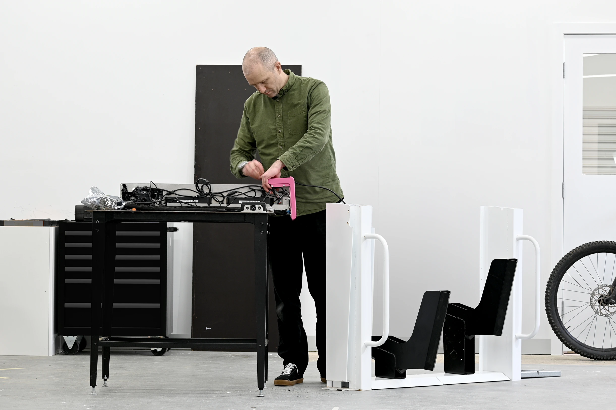 A Design engineer assembling the OneDock microFleet charging system. Designed and Engineered by Outerspace to securely lock and charge micro-mobility electric vehicles